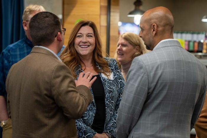 woman laughing talking to two men 